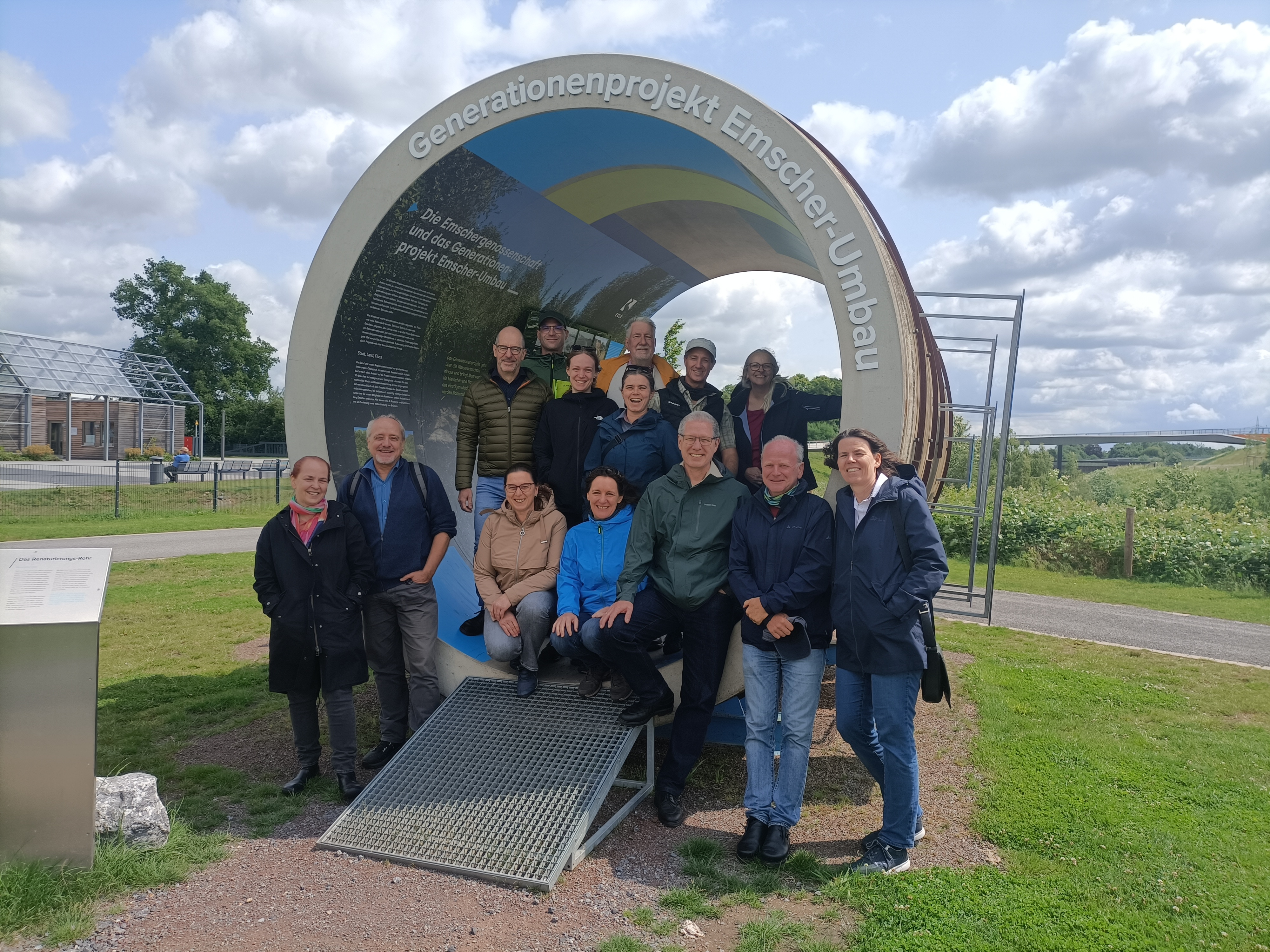 A group of people in front of the memorial site "Generationenprojekt Emscher-Umbau"