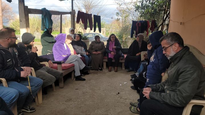 A group of people sitting on a porch during the data collection in Bebnine.