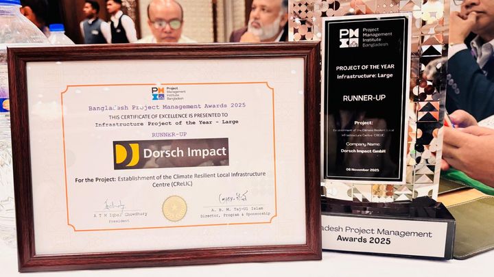 A framed certificate of excellence and the award next to another on a table.