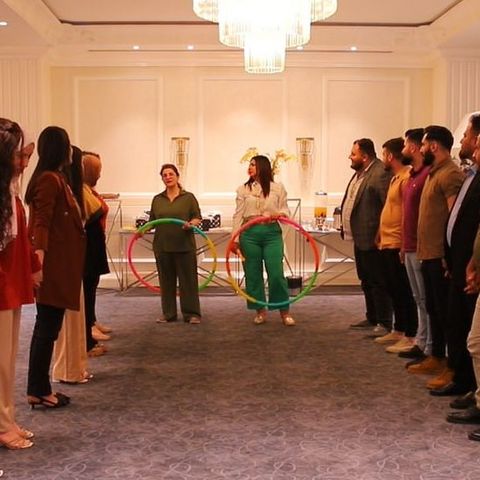 A group of young people in in a big room while participating at an interactive training session.