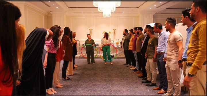 A group of young people in in a big room while participating at an interactive training session.