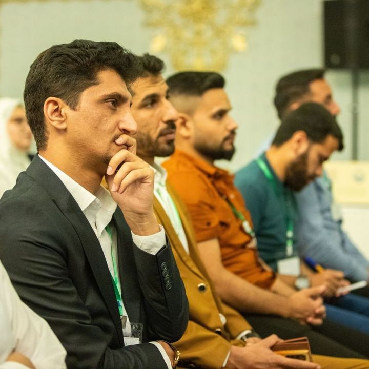 A row of young people sitting in the audience during a graduations ceremony.