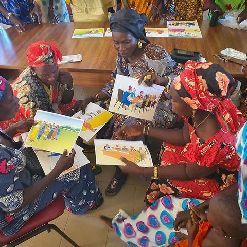 A group of Senegalese women discussing informational material on land rights. 