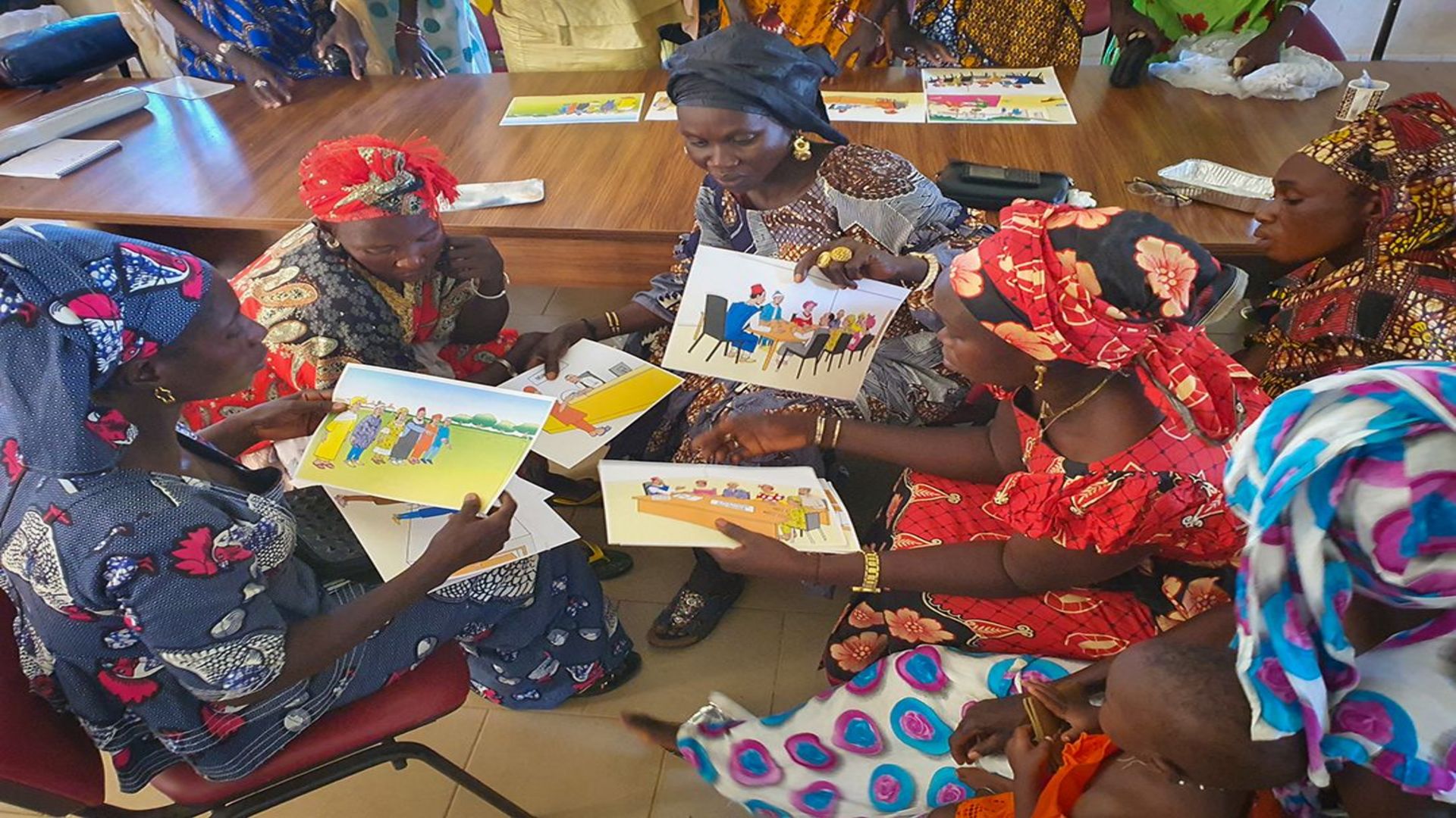 A group of Senegalese women discussing informational material on land rights. 