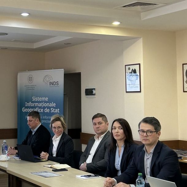 Five people sitting at a long conference table.