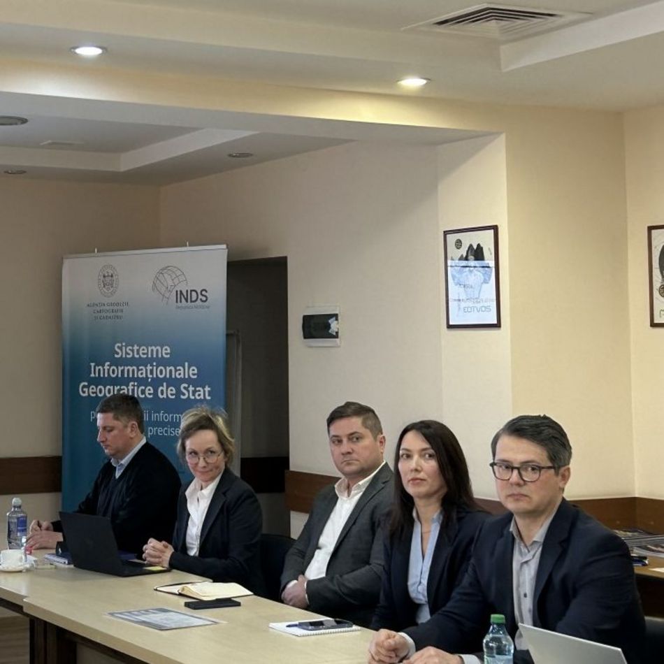 Five people sitting at a long conference table.