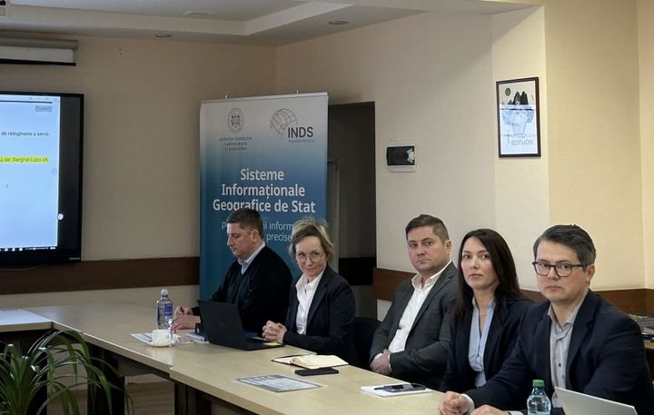 Five people sitting at a long conference table.